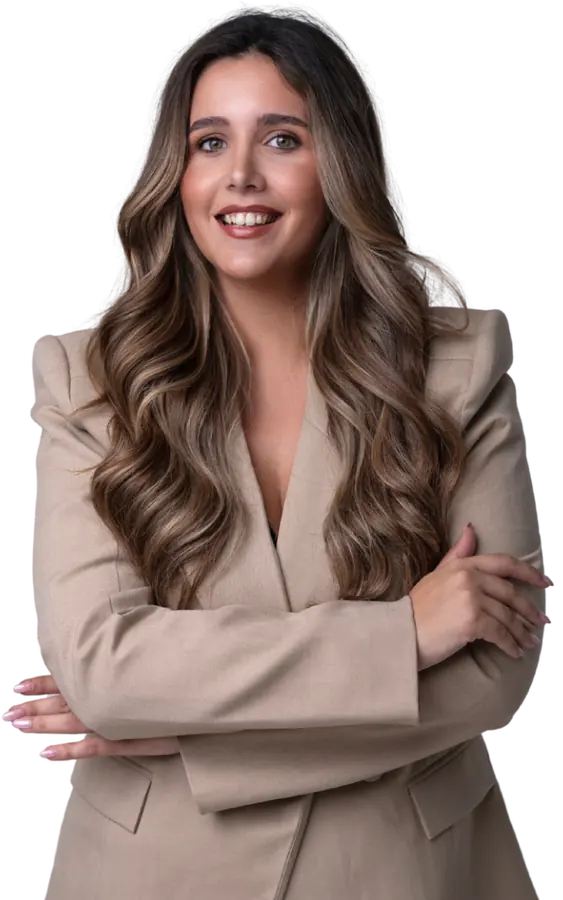 Paloma Padrón, social media manager en Málaga, sonriendo con americana beige y los brazos cruzados